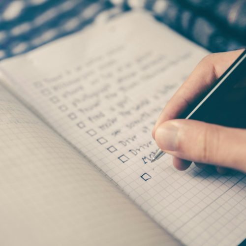 Caderno de planejamento com caneta, relógio e café sobre mesa de madeira simbolizando a rotina de melhoria contínua de 1% ao dia